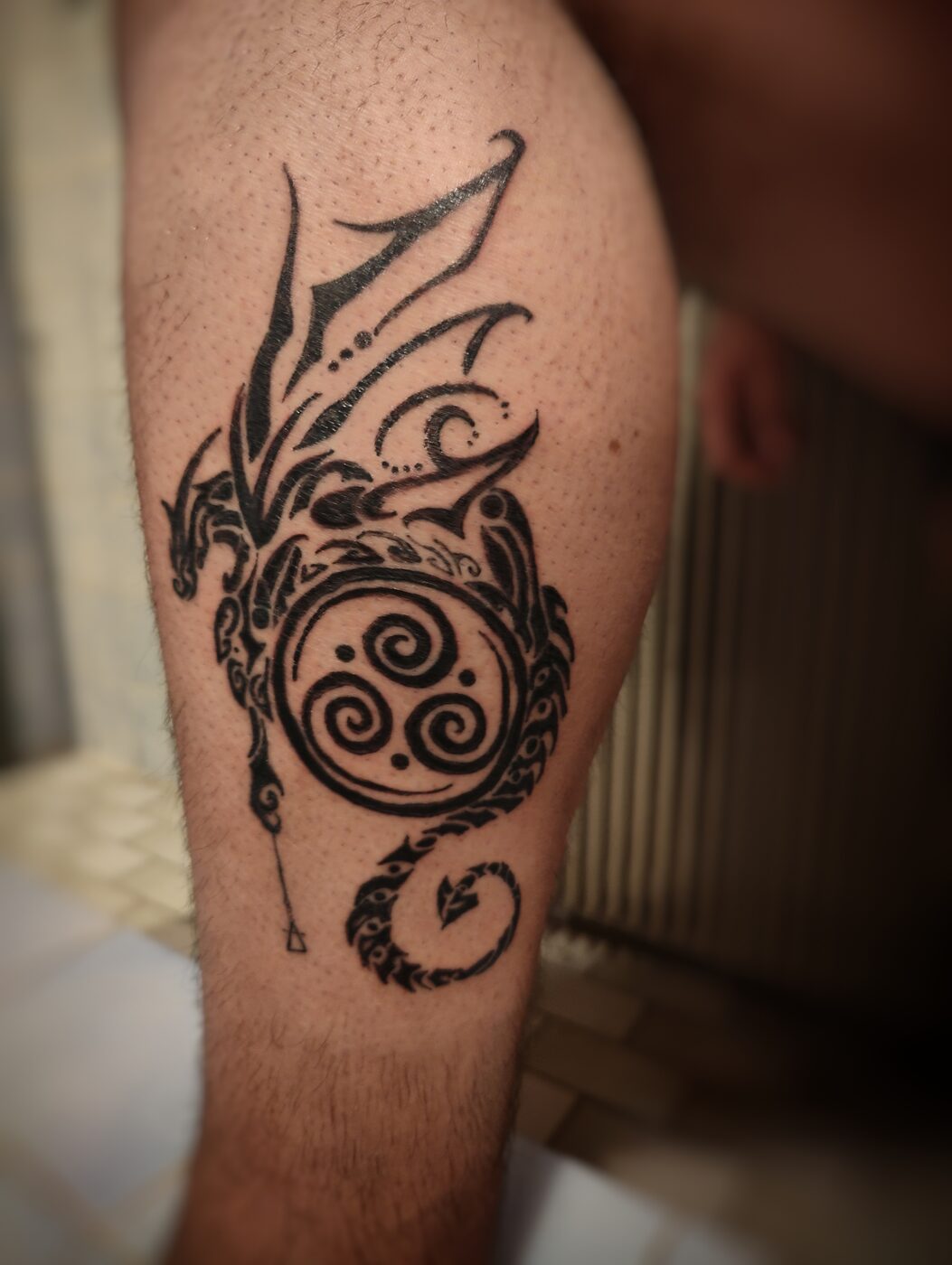 Tatouage dragon tribal sur le mollet