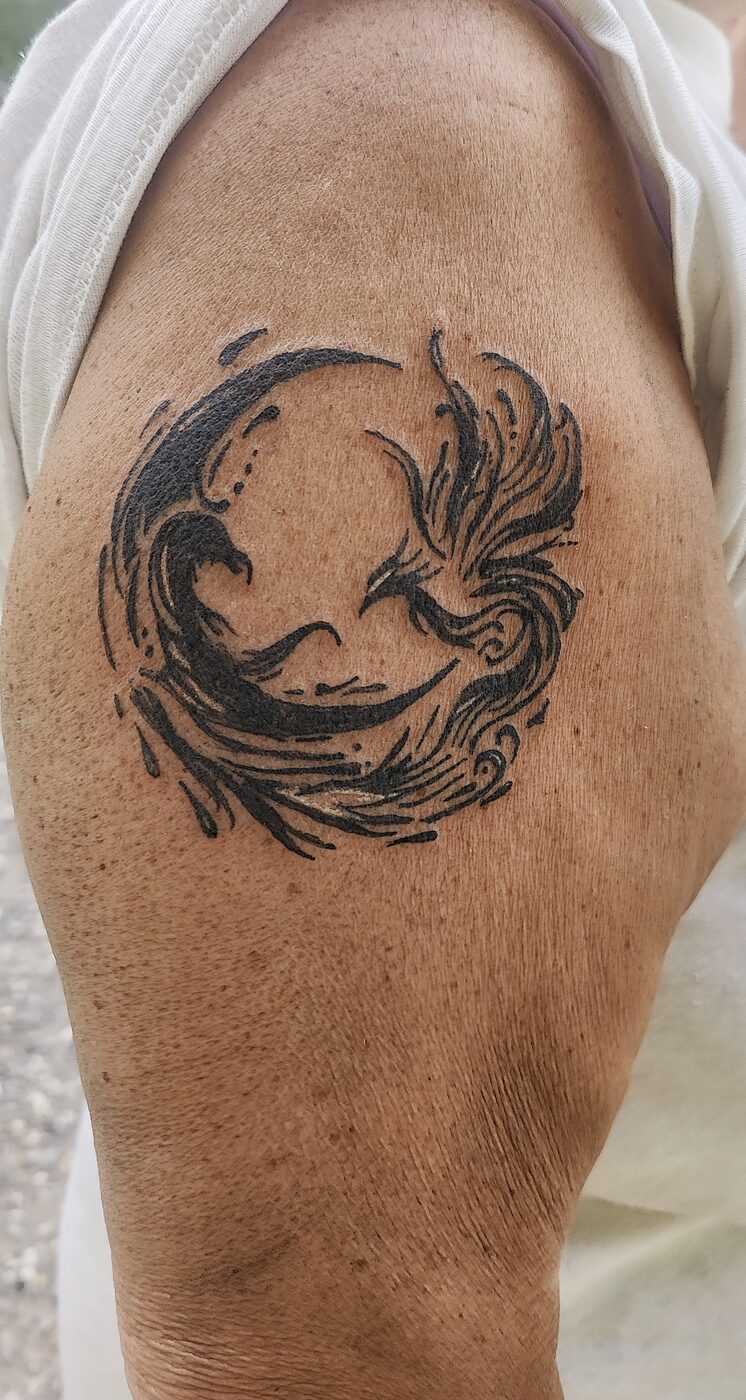 Tatouage phénix en cercle sur l'épaule
