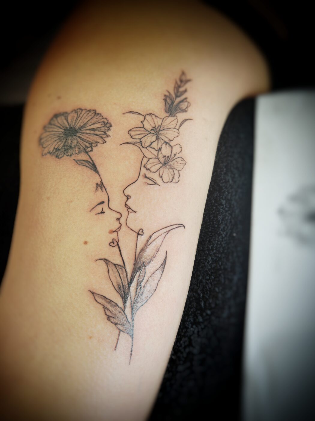 Tatouage fine line : visage de profil et fleurs